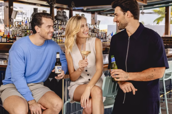 People socializing at bar with drinks in hand