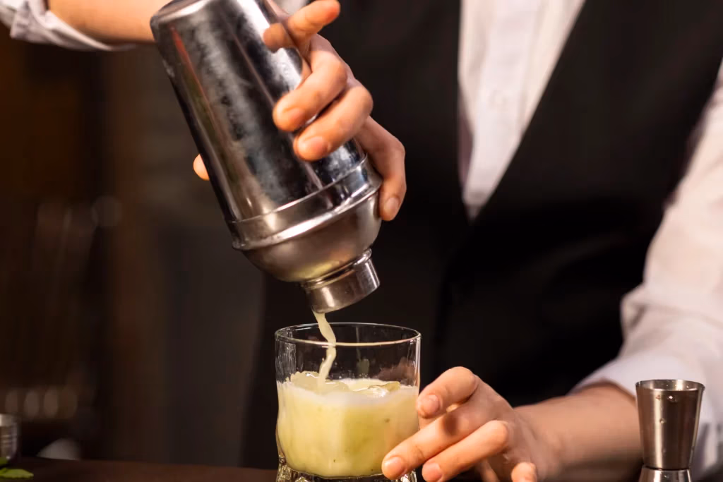 Bartender serving drink out of shaker
