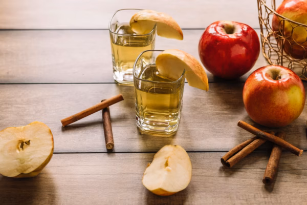 Apples juice cinnamon sticks wooden background